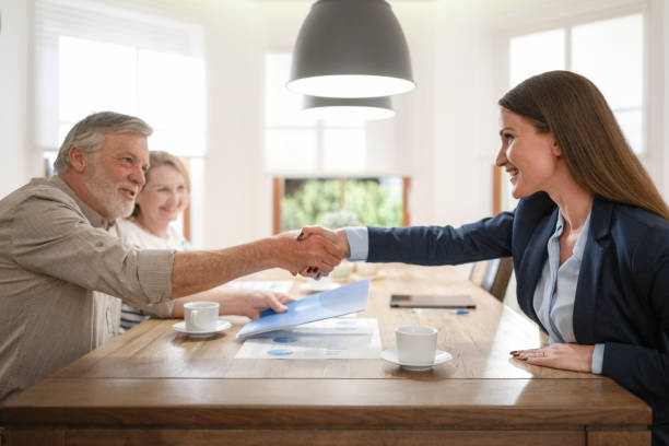 Senior couple handshaking with financial advisor