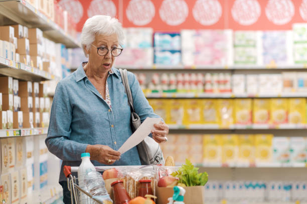 istock Shocked senior customer holding a long expensive grocery receipt 1866756990