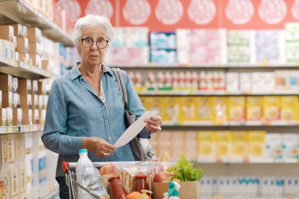 istock Shocked senior customer holding a long expensive grocery receipt 1866758573