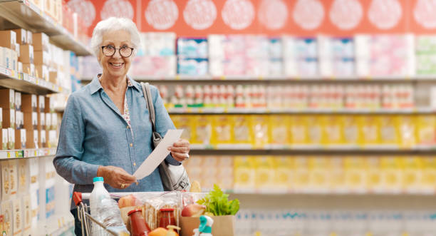istock Happy senior customer holding a long grocery receipt 1866759615