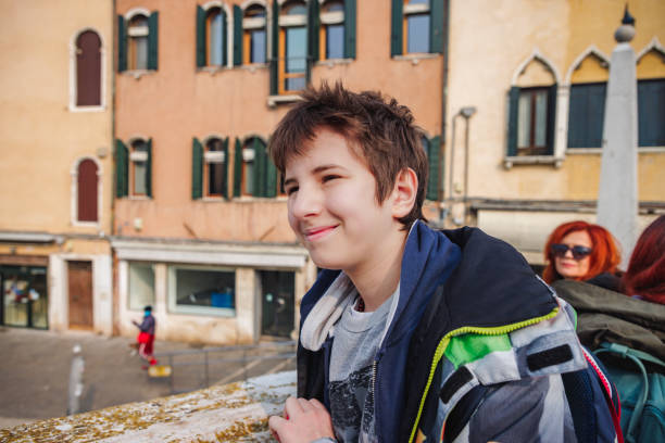 preadolescent boy standing outdoors and smiling, visiting venice with his family - travel outdoors tourist venice italy imagens e fotografias de stock