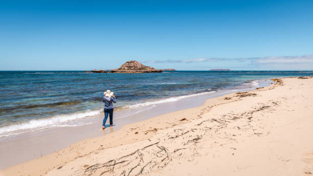 istock Woman walking along the empty beach 1866762721