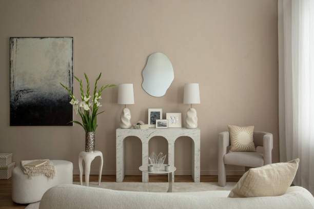 istock Warm and cozy living room interior with mock up poster frame, marble arch console, gray armchair, vase with flowers, white sofa, mirror, boucle pouf and personal accessories. Home decor. Template. 1866771071