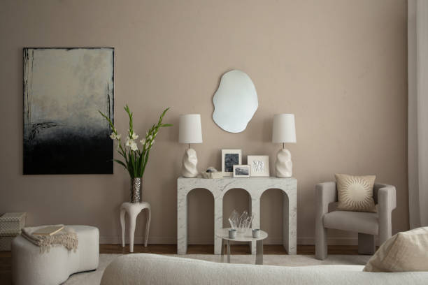 istock Warm and cozy living room interior with mock up poster frame, marble arch console, gray armchair, vase with flowers, white sofa, mirror, boucle pouf and personal accessories. Home decor. Template. 1866771602