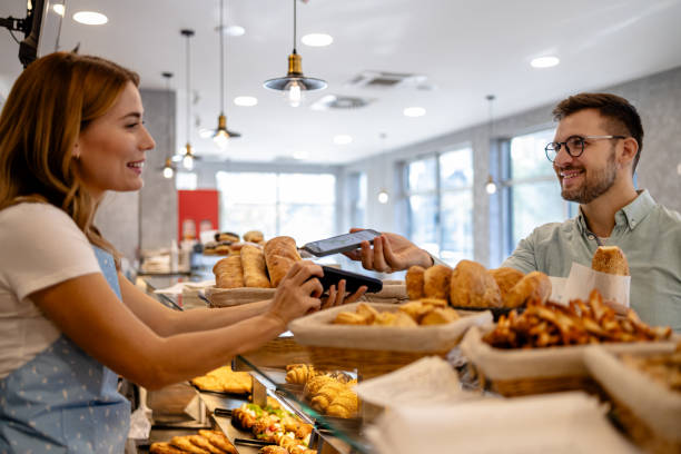 istock Mobile payment by male customer in bakery 1866774765