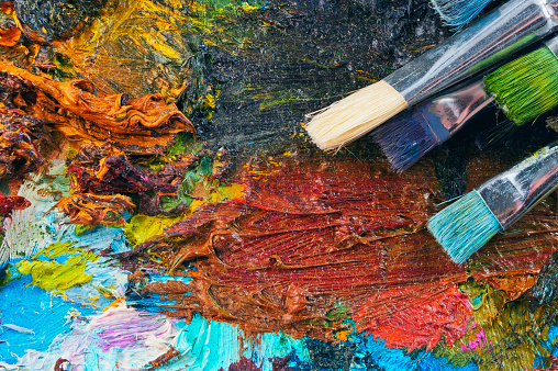 Abstract palette with brushes of hardened gouache. Abstract background. Creative workspace.