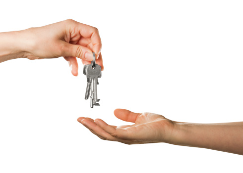 An estate agent hands the keys to the new home owner exchanging keys for a property