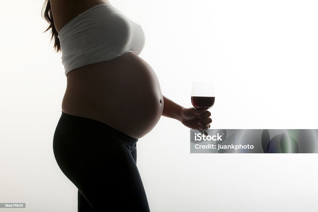 Donna incinta tenendo un bicchiere di alcol - Foto stock royalty-free di Donne