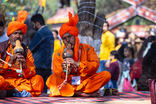 Faridabad, Haryana, India - February 2023: Portrait of male snake charmer performing during surajkund craft fair in ethnic dress to attract tourists.