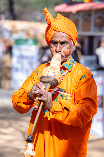 Faridabad, Haryana, India - February 2023: Portrait of male snake charmer performing during surajkund craft fair in ethnic dress to attract tourists.