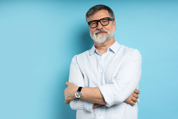 istock Bearded middle-aged man wearing glasses posing over blue studio background 1866813696
