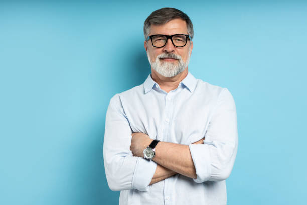 istock Bearded middle-aged man wearing glasses posing over blue studio background 1866813698