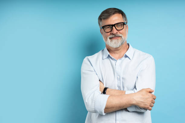 istock Bearded middle-aged man wearing glasses posing over blue studio background 1866814048