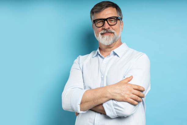 istock Bearded middle-aged man wearing glasses posing over blue studio background 1866814207