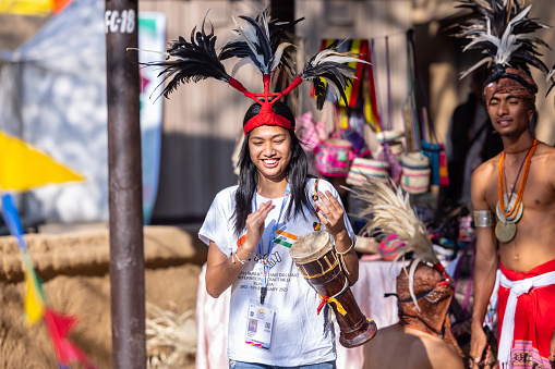 Faridabad, Haryana, India - February 2023: Portrait of female artist from nagaland playing folk musical instrument in traditional dress at surajkund craft fair.