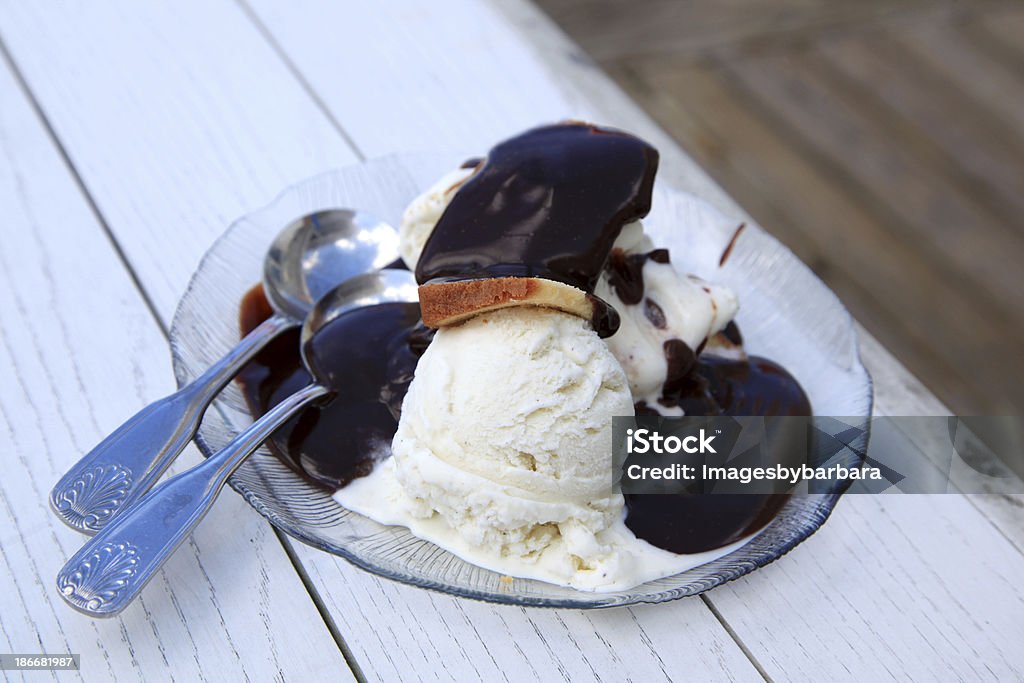 Hot Fudge Sundae Bowl of ice cream loaded with hot fudge with two spoons. Chocolate Stock Photo