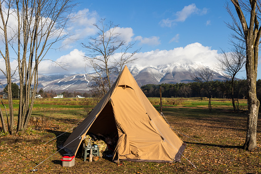 Early winter camping in North Japan with views of snowy mountains in the background.