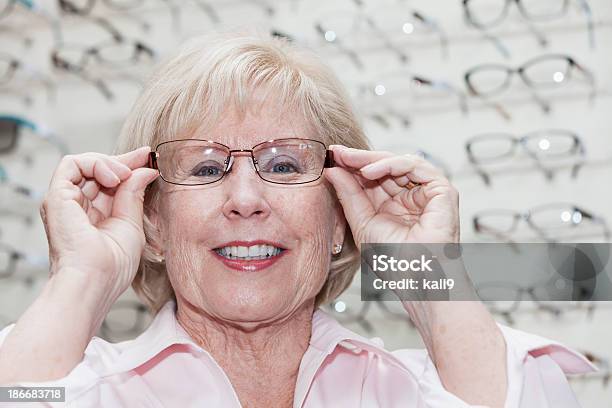 Mujer Tratando Sobre Gafas Foto de stock y más banco de imágenes de 60-69 años - 60-69 años, 65-69 años, Adulto