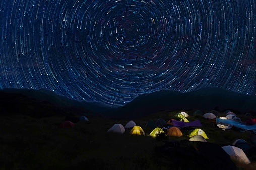 Tents at camp under starry sky at night. Astrophotography