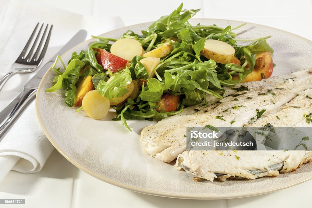 Truite préparée pour le dîner accompagné de roquette - Photo de Ail - Légume à bulbe libre de droits