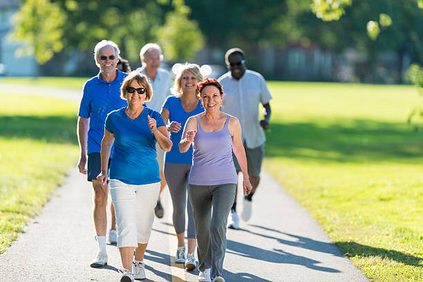 istock Elderly people exercise by walking in park 186684756
