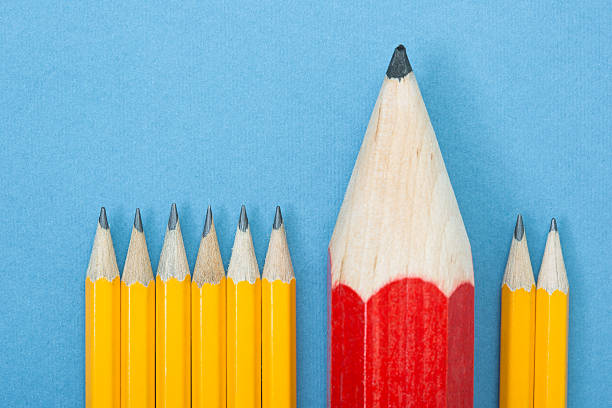istock Large red pencil among several small yellow pencils 186684853