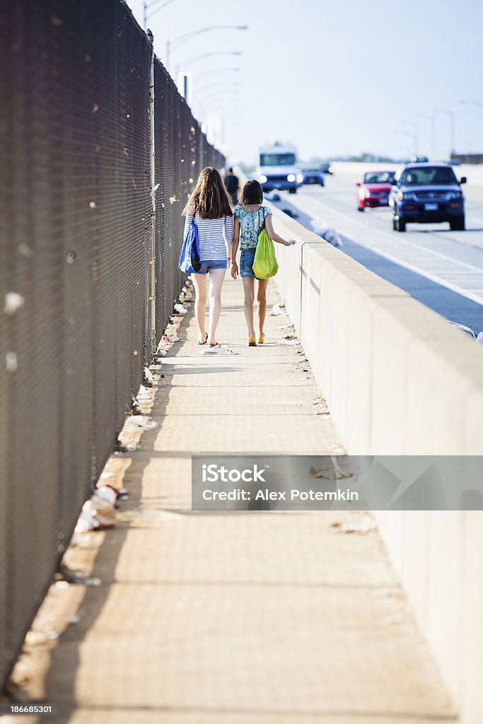 Due ragazze camminare sopra un ponte nella zona industriale - Foto stock royalty-free di 12-13 anni