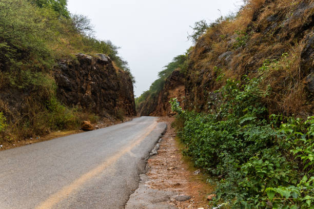isolate tarmac road leading to mountains at rainy day from flat angle