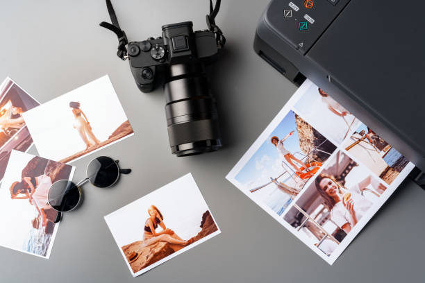 istock Photo camera with colorful printer photos on gray desk 1866859568