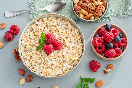 Bowl of porridge or oatmeal with fruits close up. Breakfast concept.