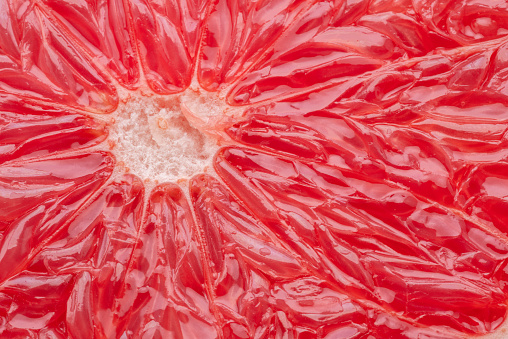 Juicy segmented flesh of grapefruit closeup. Food background.