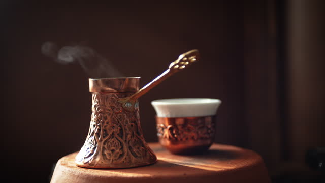 Steamy Turkish Coffee pot known as Cezve or Jezve and coffee cup