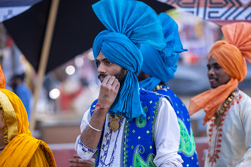 Faridabad, Haryana, India - February 2023: Portrait of male sikh in traditional punjabi clothes and turban at surajkund craft fair. Punjabi artist participate to perform bhangra dance.