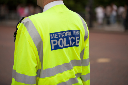 London metropolitan Police officer patrolling crowds on the Mall, London, UK