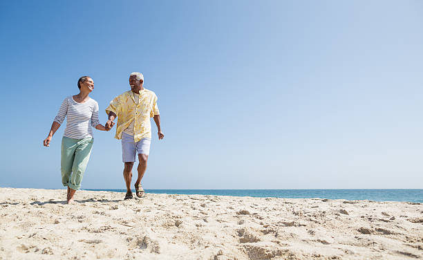 attivo coppia senior sulla spiaggia - couple romance running freedom foto e immagini stock