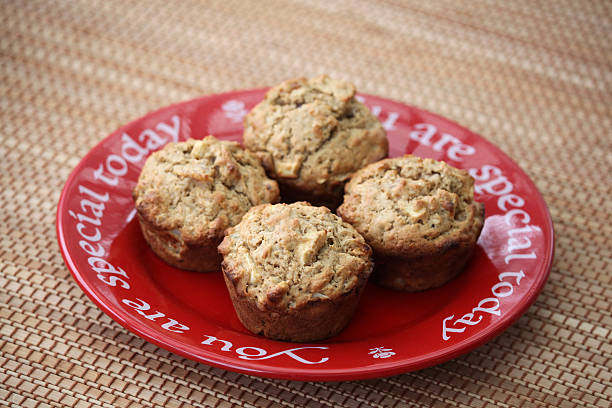 Four Healthy Apple, Apricot, and Walnut Muffins on Red Plate Apple, apricot, and walnut muffins on a red plate is a healthy and delicious breakfast alternative. Focus is on the muffin in front. Slective Focus stock pictures, royalty-free photos & images