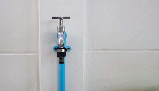 Hand-crank faucet mounted on a white wall.