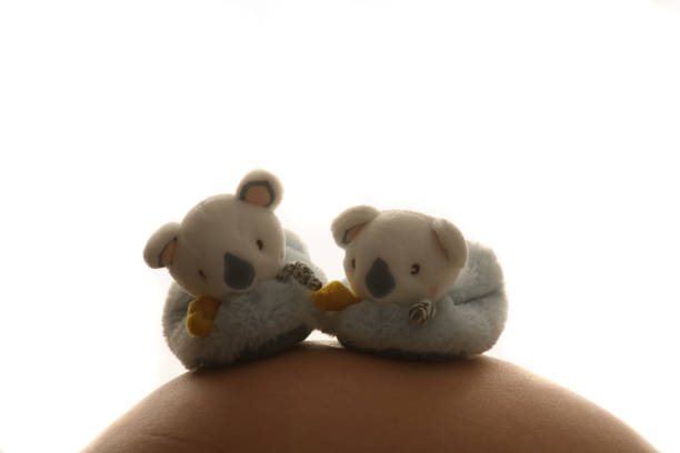 a pregnant woman in a white T-shirt and blue jeans. Close-up of the baby. Dad and mom's hands. Ivf, family, love, family planning, gynecologist, doctor, children. High quality photo