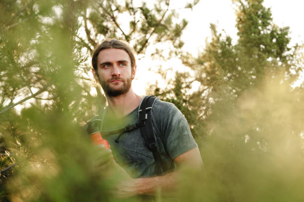 istock Hiker man with backpack holding thermos in his hand 1866888052