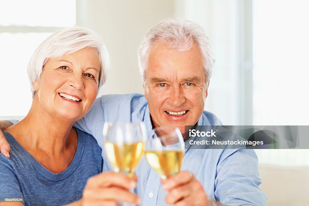 Loving Couple Senior portant un toast à vin à la maison - Photo de 60-64 ans libre de droits