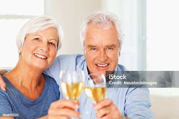 Photo libre de droit de Loving Couple Senior Portant Un Toast À Vin À La Maison banque d'images et plus d'images libres de droit de 60-64 ans