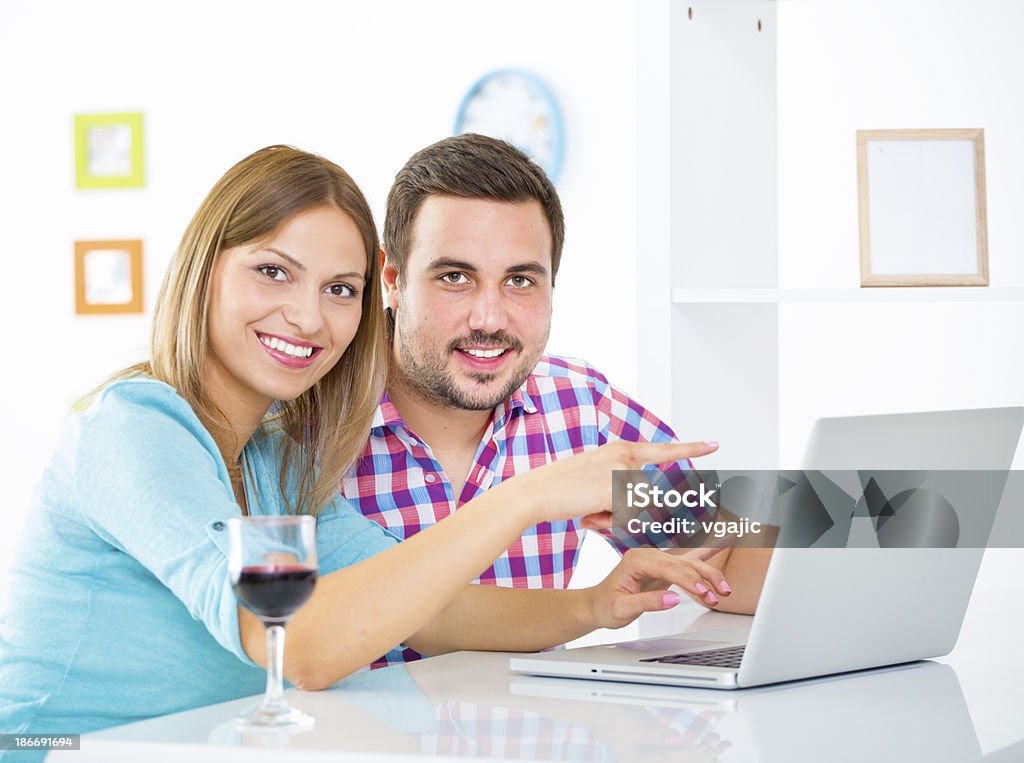 Allegro giovane coppia utilizzando un computer portatile. - Foto stock royalty-free di Adulto