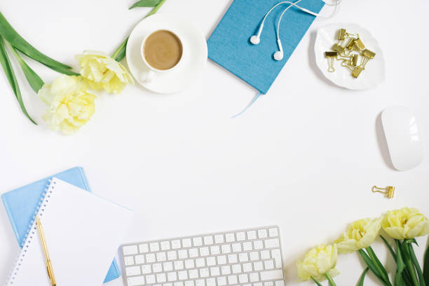istock Office desk with notepad, computer, headphones and tulip flowers. Top view with copy space 1866916970