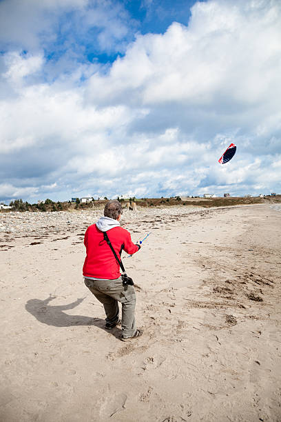 istock mature man flies kite sunny day on empty beach 186691908