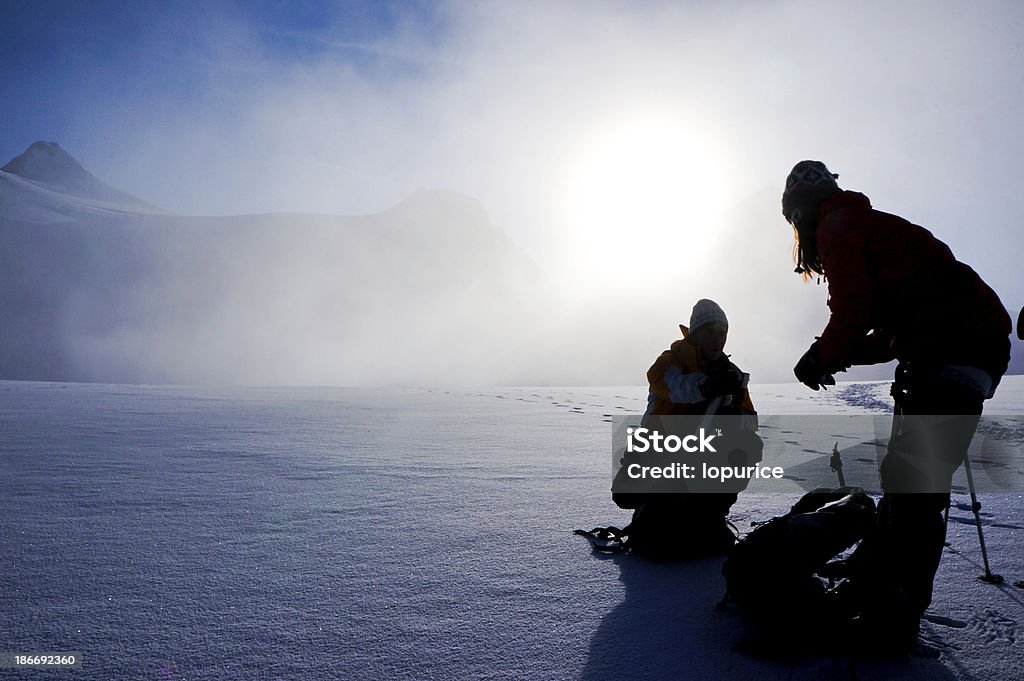 storm on the ice two climber during a snow storm. Idea of winning against nature adversity stregth and help each other Adult Stock Photo