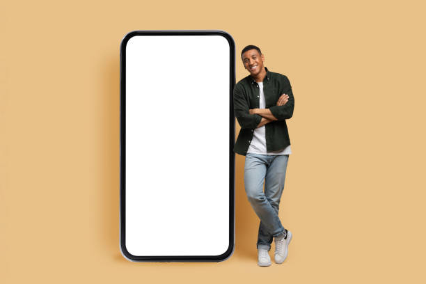 istock Happy young black man posing by phone with white screen 1866925383