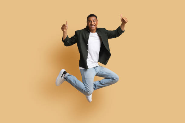 istock Happy black man jumping up and showing thumb ups 1866925387