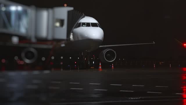 Airplane with a ramp at the airport at night.