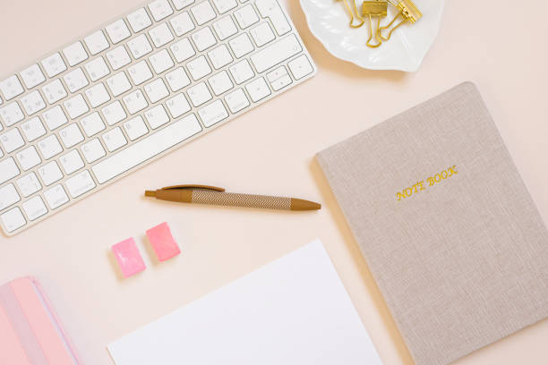 istock A woman's workplace with beige notebook, a computer keyboard and a pen. Top view, flat lay. 1866930581
