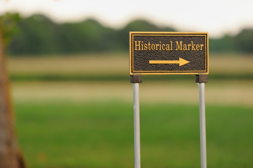 Close up of directional road sign for historical marker.